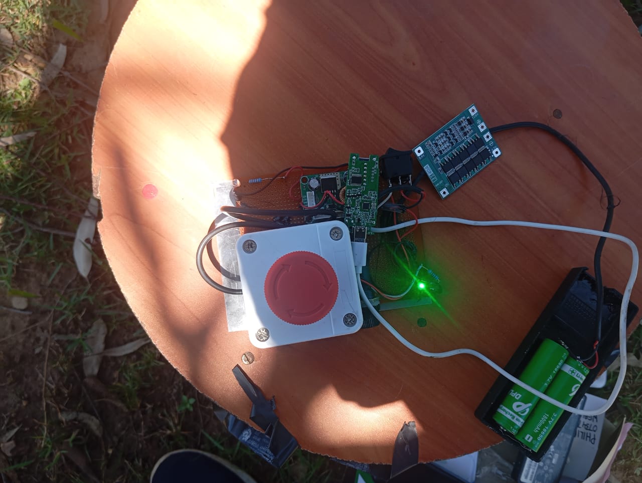 TUS-27 field test Sunday 4 Oct 2026 River Nzoia Bridge Bungoma — on stool under tree, 2S 18650 pack 8.4V max regulated to 5.0V output, bench 05.0V→00.0V e-stop